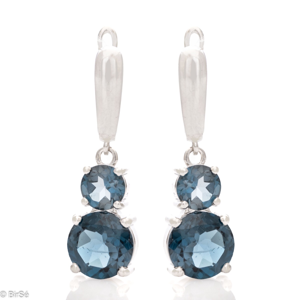 Delicate dangling earrings with an interesting design and radiant natural London topaz. They are made entirely of beautiful rhodium silver with a comfortable English clasp. A spectacular ring and pendant complete the set.