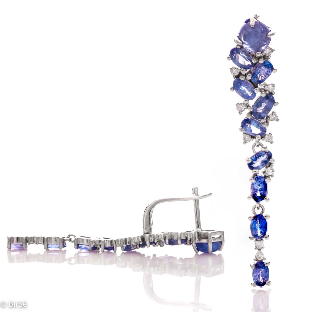 Elegant women's English clasp earrings, resembling a waterfall of numerous natural tanzanite stones, complemented by delicate zircons and a delicate rhodium-plated silver design. In an exclusive pendant and ring set.